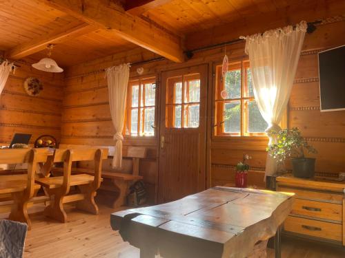 什切尔克SkiBajkowa Chata的小木屋内带桌子的用餐室