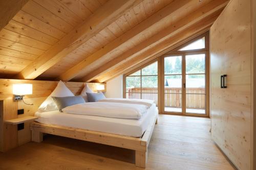 格赖瑙Zugspitzerei - Premium Chalet Ferienwohnungen的木屋内的卧室配有一张床