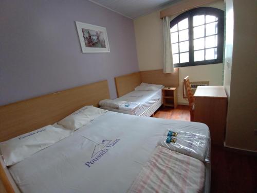 圣保罗Hotel Pousada Viana的小房间设有两张床和窗户