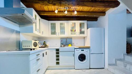 利纳雷斯德拉谢拉La Cantarera的厨房配有白色橱柜、洗衣机和烘干机