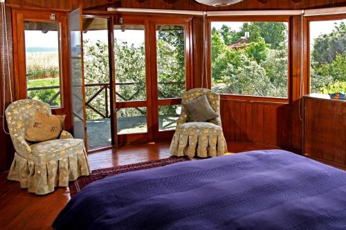 伯萨Perfect Home with Private Beach by Iznik Lake的一间卧室配有一张床、两把椅子和窗户