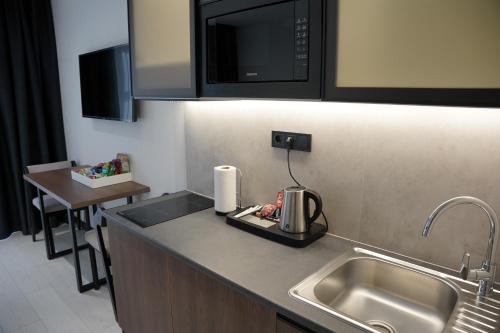 布克维BUKA Apart-Hotel & SPA的厨房柜台设有水槽和微波炉