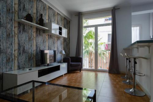 加的斯Apartamentos El BALNEARIO by Cadiz4Rentals的客厅配有玻璃桌和电视