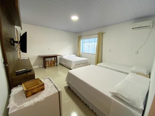 佩尼亚Calefe Suítes的酒店客房设有两张床和电视。