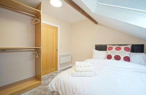 哈德斯菲尔德Alpha Lofts, Huddersfield的卧室配有白色大床和红色及白色枕头