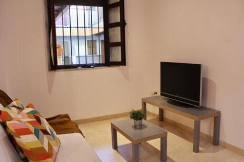 塞维利亚WISH SUITE MORERA的客厅配有餐桌上的平面电视