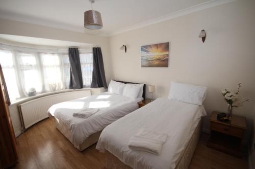 莱斯里普Deane House的配有白色床单的客房内的两张床