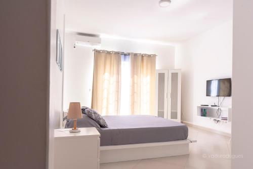 普拉亚Urban Aparthotel的白色的卧室设有床和窗户