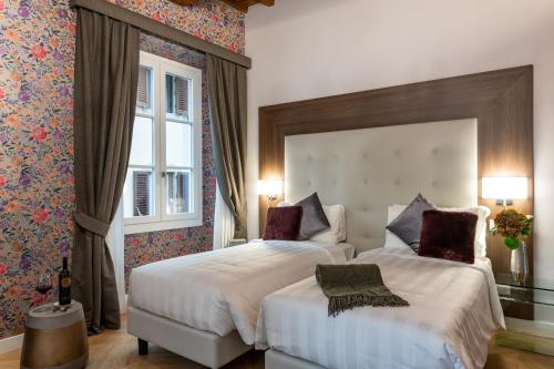 佛罗伦萨Kairos by Florence Art Apartments的酒店客房设有两张床和窗户。