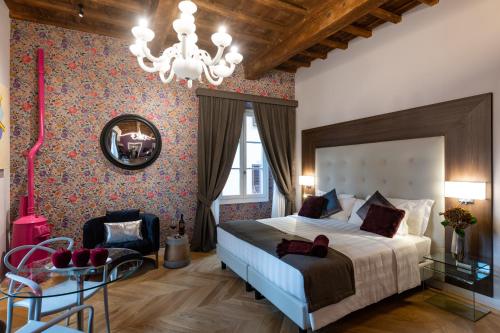 佛罗伦萨Kairos by Florence Art Apartments的一间卧室配有一张大床和一个吊灯。
