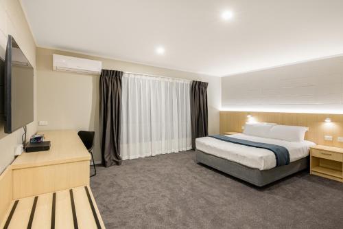 奥克兰塔卡普纳国际汽车旅馆的配有一张床和一台平面电视的酒店客房