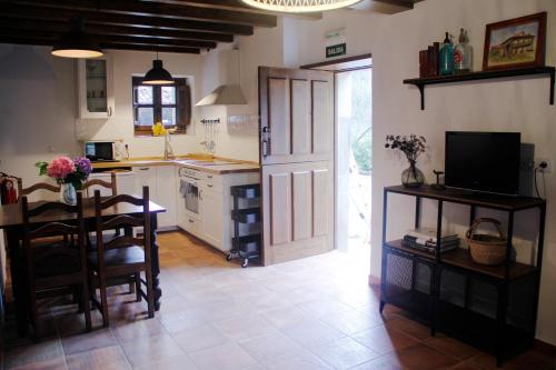 里瓦德塞利亚El Molín de La Vega Agroturismo的一间带桌子的厨房和一间餐厅