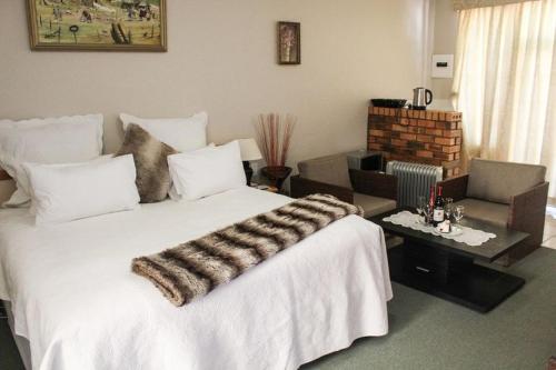 LeribeMountain View Hotel - Lesotho的一间带白色大床的卧室和一间客厅