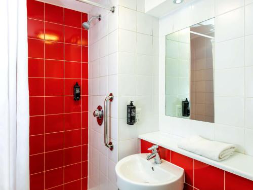 特伦特河畔伯顿ibis budget Burton Upon Trent Central的红色和白色的浴室设有水槽和镜子
