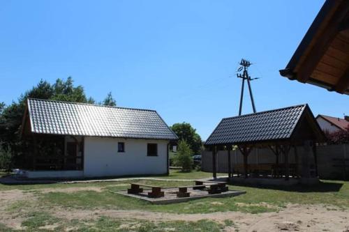 ŚwiętneDomek letniskowy 6-osobowy całoroczny nad jeziorem Wilczyńskim的一座带野餐桌和凉亭的建筑