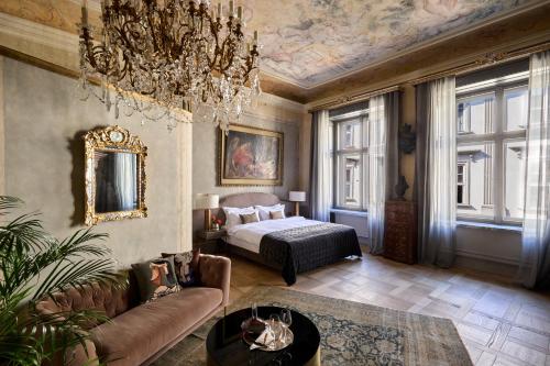 克拉科夫Hotel H15 Luxury Palace的一间带一张床和吊灯的客厅