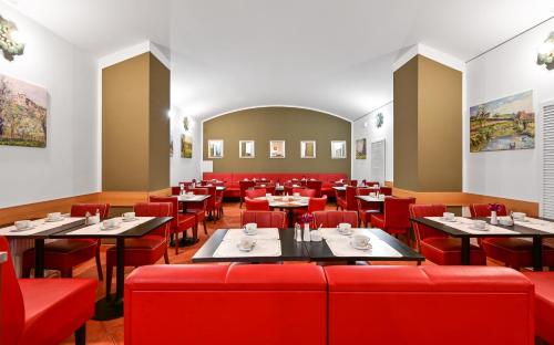 布拉格马拉斯德拉娜酒店的一间设有红色桌子和红色椅子的餐厅