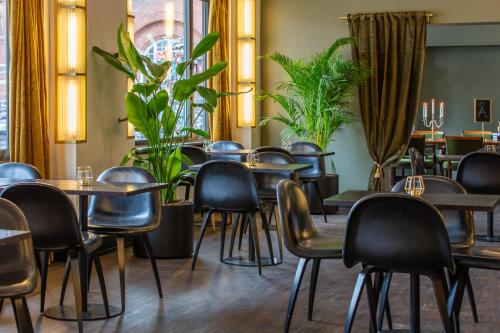 哥本哈根Hotel Astoria, Best Western Signature Collection的一间设有桌椅的餐厅,种植了植物