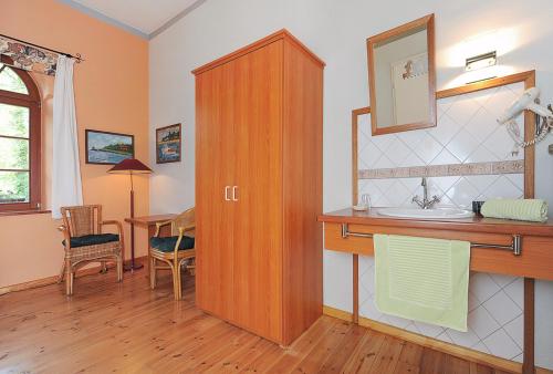 丹加斯特Pension Altes Posthaus的一间带水槽和木制橱柜的浴室