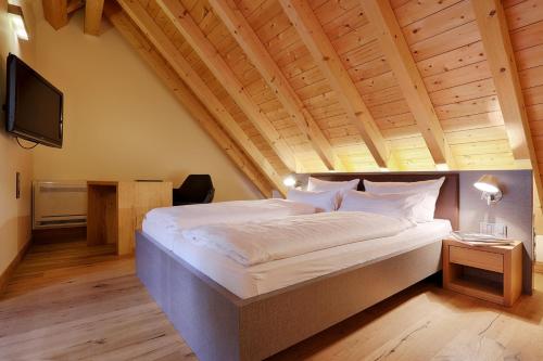 法伊茨赫夏伊姆HOTEL WIENER BOTSCHAFT Veitshöchheim - by homekeepers的一间卧室设有一张带木制天花板的大床