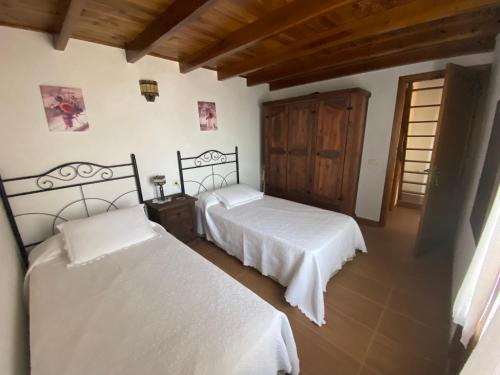 巴尔韦尔德Pajero Las Cadenas的一间卧室设有两张床和木门