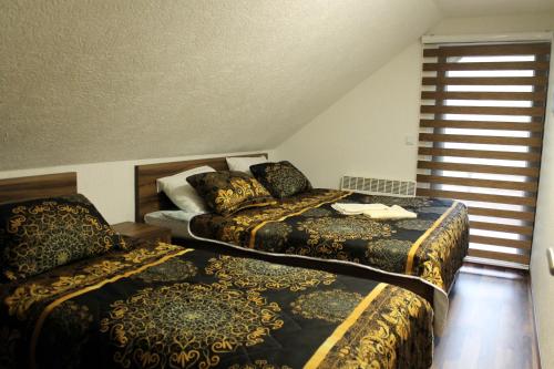 萨拉热窝Vikendica Bjelašnica的酒店客房设有两张床和窗户。