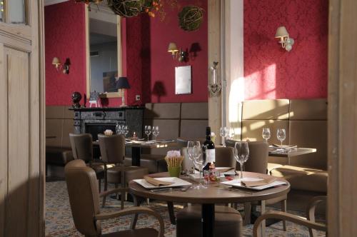 PoelkapelleOud Gemeentehuis的一间带桌椅和红色墙壁的餐厅