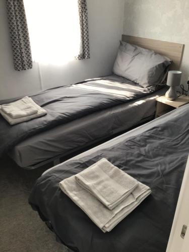 伊尔弗勒科姆Peaceful Paradise的卧室内的两张床,配有两条毛巾