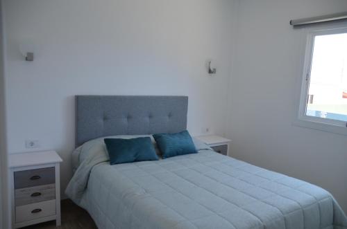 Las PuntasCASA MAR AZUL的一间卧室配有一张带蓝色枕头的床和一扇窗户。