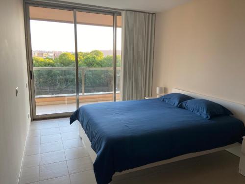 吉亚Herdade dos Salgados - Apartamento T2的一间卧室设有蓝色的床和大窗户