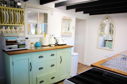 法拉姆灵厄姆Romantic* Castle on the Hill Cottage *Framlingham的厨房配有蓝色橱柜和台面