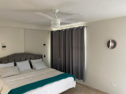 海地角Mountain View Hotel and Bar Restaurant的一间卧室配有一张带吊扇的床