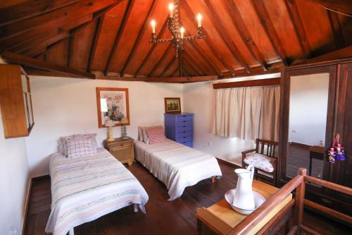 克鲁兹·德·特赫达La Ventana del Bentayga的一间卧室配有两张床和吊灯。