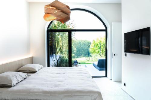 Sint-Pieters-LeeuwWellness Suite B&B L'O Reine的一间卧室设有一张大床和一个大窗户