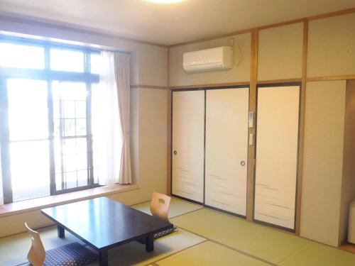 高山高山日式旅馆的客房设有桌子和大窗户。