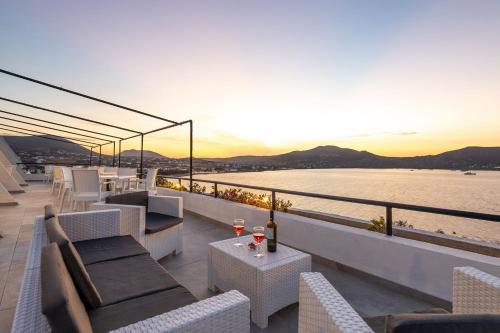 纳乌萨海马酒店的阳台配有沙发和桌子,享有水景