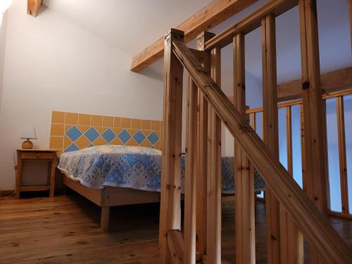 圣马迪拉莫Le Cocardier的一间卧室设有一张床和木制楼梯。