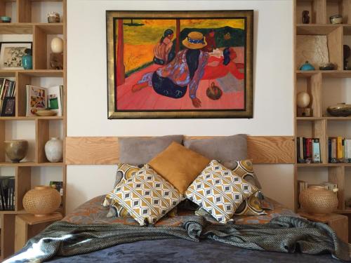 贝隆河畔日克Les 3 Koïs的卧室配有带枕头的床上方绘画