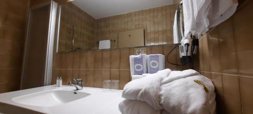 MadonnaSmart Hotel Firn的浴室配有盥洗盆、镜子和毛巾