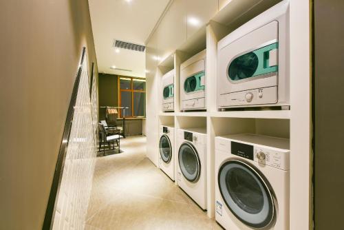 包头包头稀土高新亚朵酒店的洗衣房配有2台洗衣机和烘干机