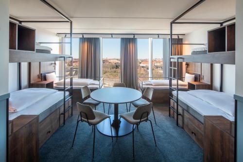 哥本哈根Comfort Hotel Copenhagen Airport的客房设有两张双层床和一张桌子及椅子。