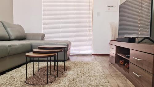 波罗瓜尼Platinum Apartment的客厅配有沙发和2张桌子