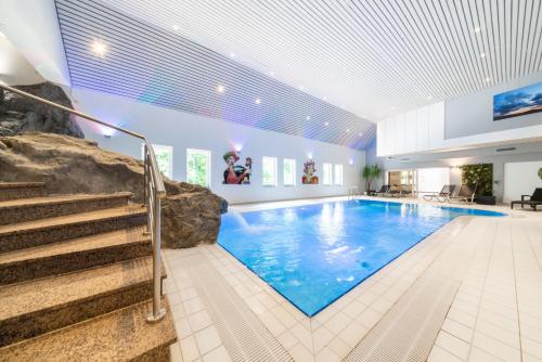 克莱沃Le Clervaux Boutique Hotel & Spa的一座带楼梯的大型游泳池以及一座大型游泳池