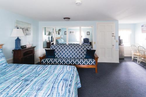 West Harwich海滩微风汽车旅馆的一间卧室配有一张床、一张沙发和一面镜子