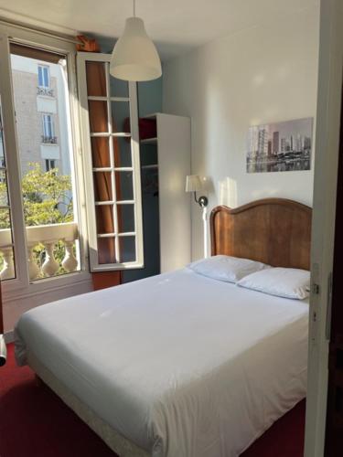 巴黎魏尔伦酒店的卧室配有白色的床和窗户。