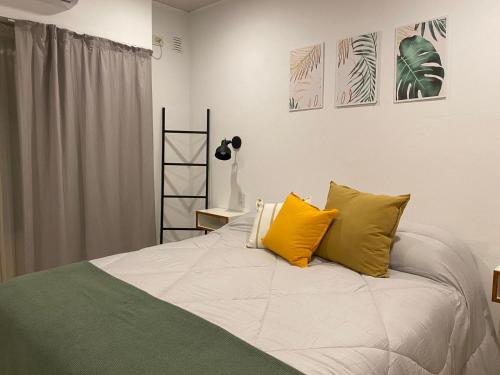 贝伦埃斯科巴Studio Estrada 2 Escobar的一间卧室配有一张带两个黄色枕头的床