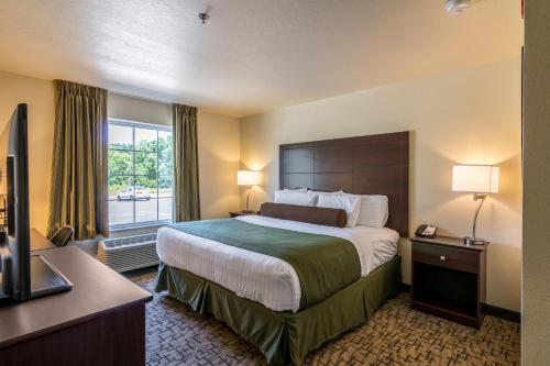 BarronCobblestone Inn & Suites - Barron的一间设有大床和窗户的酒店客房