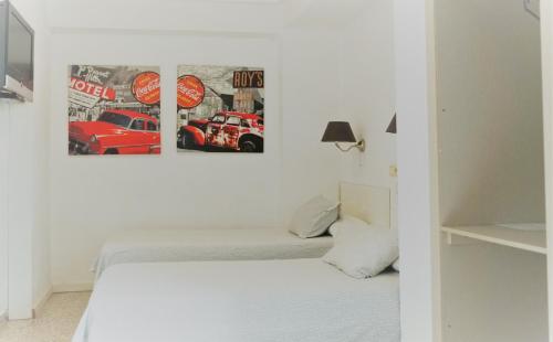 瓦伦西亚瓦伦西亚多米尔旅舍的白色卧室的墙上贴有两张海报