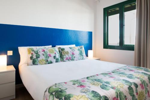 普拉亚布兰卡Blancazul Tegala的卧室配有白色床和蓝色墙壁