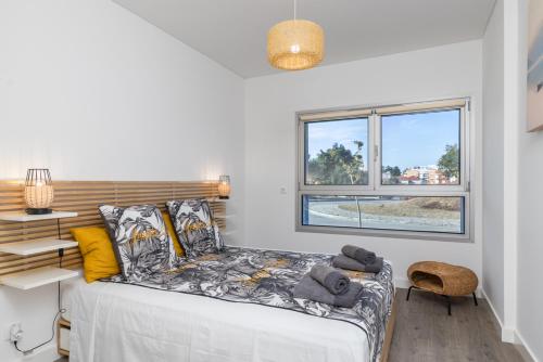 塞沙尔One River Seixal的一间卧室设有一张床和一个窗口